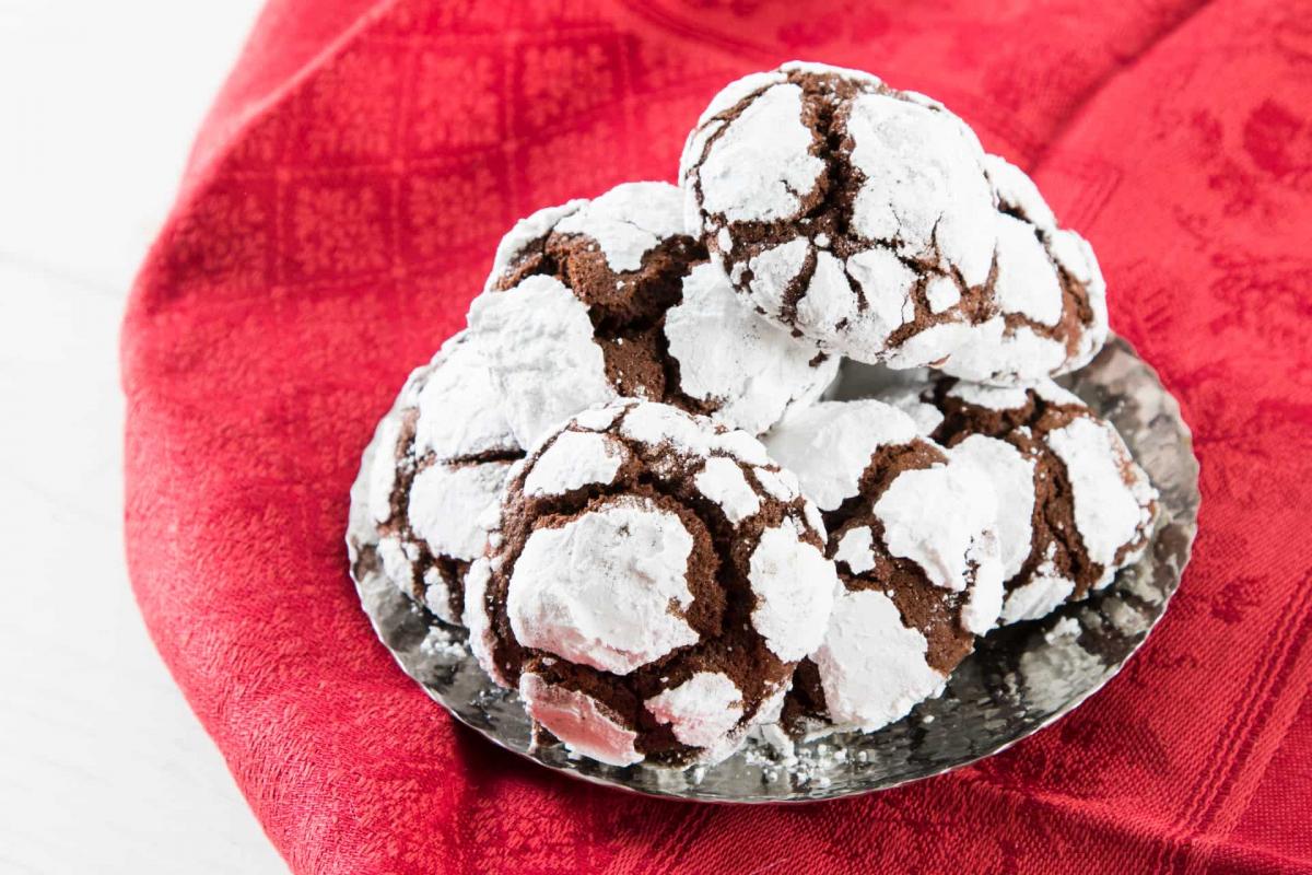 Chocolate crinkle cookies on a silver plate with a red table cloth