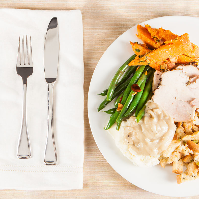 one plate of holiday food with napkin and utensils